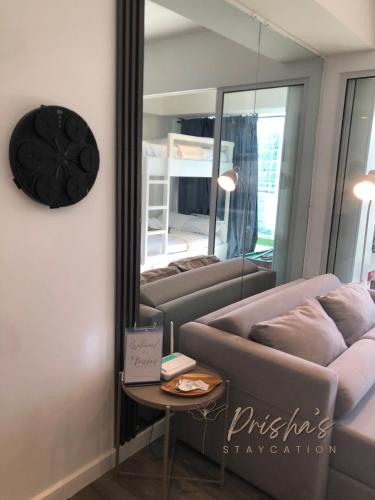 a living room with a couch and a mirror at Prisha Staycation in Manila