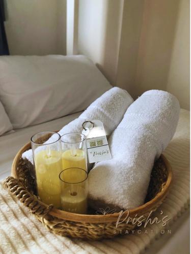 a basket of towels and candles on a bed at Prisha Staycation in Manila