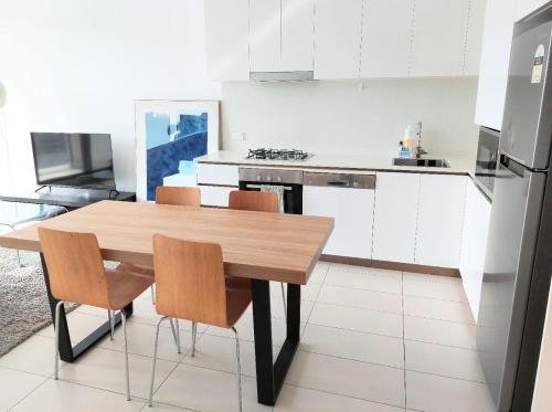 a kitchen with a wooden table and two chairs at Modern 5-Guest Pool Retreat for Family & Business in Brisbane