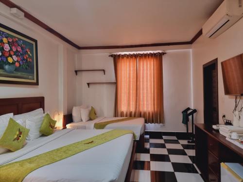a hotel room with two beds and a checkered floor at Maison Saiko Angkor Boutique in Siem Reap