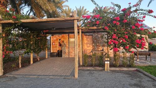 a wooden boardwalk with flowers on a building at Gazelle Estate in Kakamas