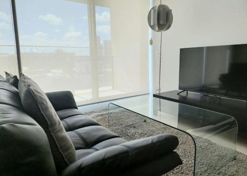 a living room with a couch and a television at Modern 5-Guest Pool Retreat for Family & Business in Brisbane