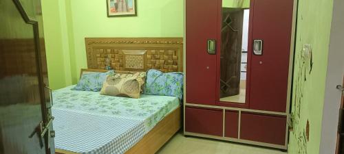 a small bedroom with a bed and a mirror at sushma's homestay in Prayagraj