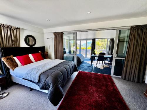 a bedroom with a large bed and a red rug at Airport Guesthouse in Queenstown