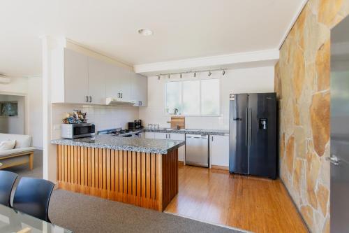 a kitchen with a black refrigerator and a counter at Yarra Valley Grand in Yarra Glen