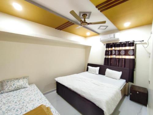 a bedroom with a bed and a ceiling fan at Aarambh Home stay in Garudeshwar