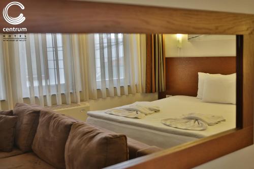 a hotel room with a bed and a couch at Hotel Centrum Prizren in Prizren