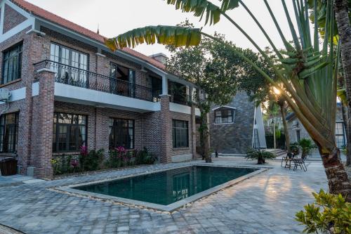a house with a swimming pool in front of it at Villa 1972 - Ninh Binh - Cuc Phuong Nature Retreat in Ninh Binh