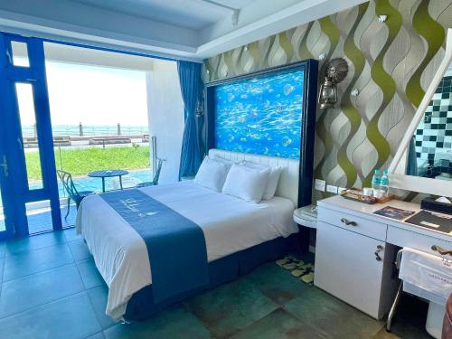 a bedroom with a bed and a desk and a window at Hualien S.E.A. B&B in Hualien City