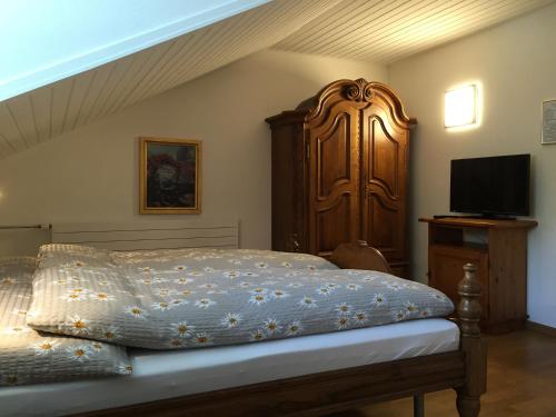 a bedroom with a bed with a wooden headboard at Hotel Römerhof in Brigerbad