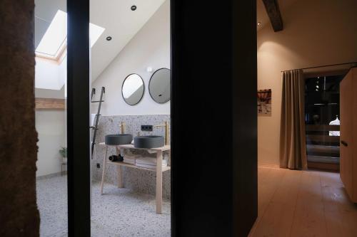 a bathroom with two sinks and mirrors on the wall at das 1494 Wohnen und Kultur im Denkmal in Mieming