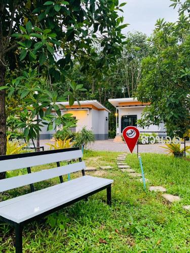 a bench with a stop sign next to a house at Suanvadee Resort สวนวดี รีสอร์ท in Don Sak