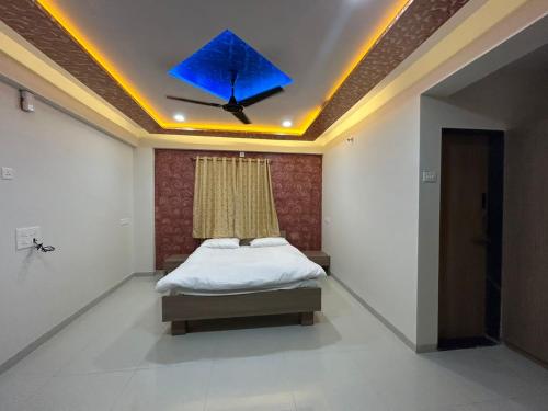 a bedroom with a bed with a blue object on the ceiling at Shourya Homes in Arvi