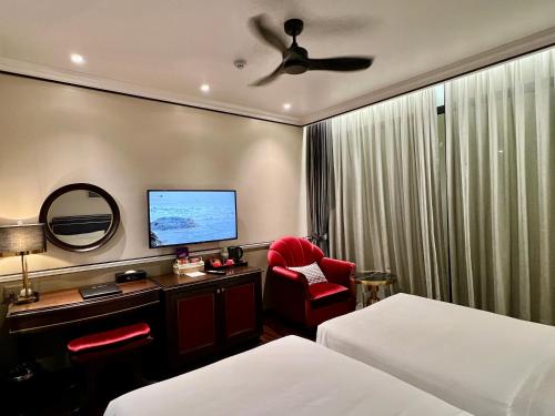 a hotel room with a bed and a desk with a tv at Hotel du Monde Art in Hanoi