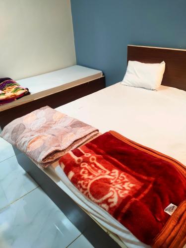 a bed with a red blanket on it in a room at Aarambh Home stay in Garudeshwar
