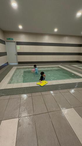 two toy children playing in a swimming pool at farissa homestay in Melaka