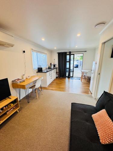 a living room with a table and a kitchen at Modern 1 bedroom guest house in Upper Hutt