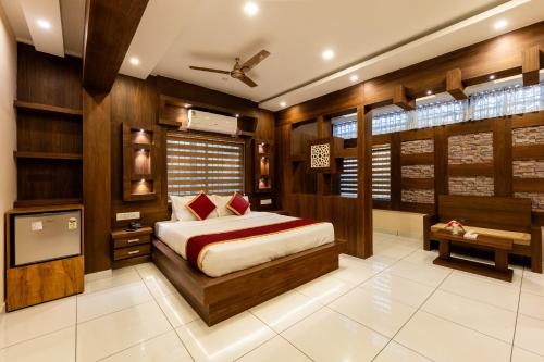 a bedroom with a bed and a desk and a tv at MARZA INN in Kalpetta