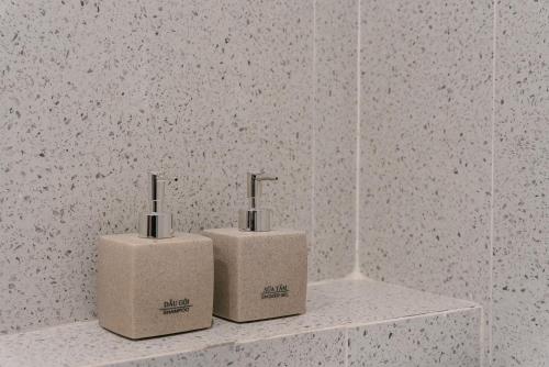 two complimentary toothbrushes sitting on a shelf in a bathroom at An Nguyen Lakeside Residence in Hanoi