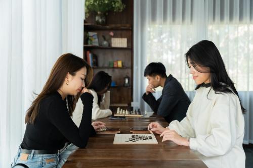 two women standing at a table playing a game at Villa 1972 - Ninh Binh - Cuc Phuong Nature Retreat in Ninh Binh