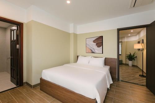 a bedroom with a large white bed and a mirror at An Nguyen Lakeside Residence in Hanoi