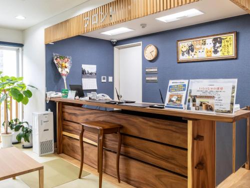 an office with a wooden counter with a clock on the wall at Business Hotel Awaikeda Eleven 2 in Miyoshi