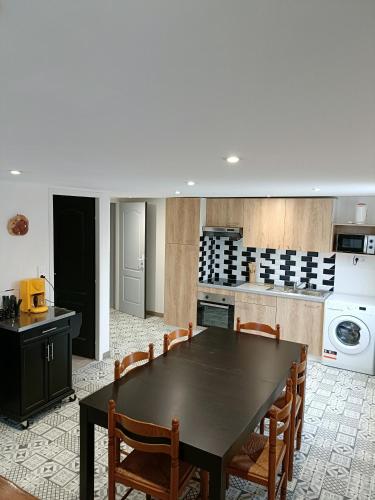 une cuisine avec une table noire et des chaises en bois dans l'établissement La détente, à Saint-Georges-de-Pointindoux