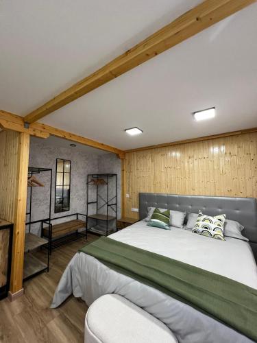 a large bed in a room with wooden walls at Casa Rural Renueva en Buendía in Buendía