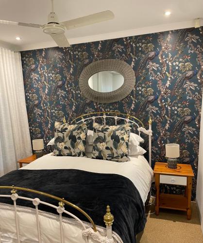 a bedroom with a bed with a floral wallpaper at Lavender Cottage in Hillcrest
