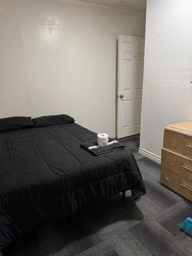 a bedroom with a black bed and a dresser at Cozy Routes at El Monte in El Monte