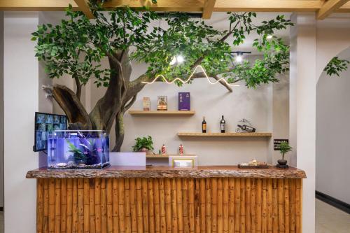 un albero dietro un bancone con un acquario di Longji Thousand - layer Terraces View Hotel a Longsheng