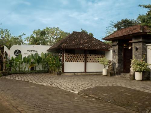 a house with a gate and a brick driveway at Tattva Ubud Retreat & Wellness in Ubud