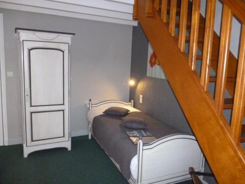a bedroom with a bed and a stair case at Hôtel Picardia in Saint-Valery-sur-Somme
