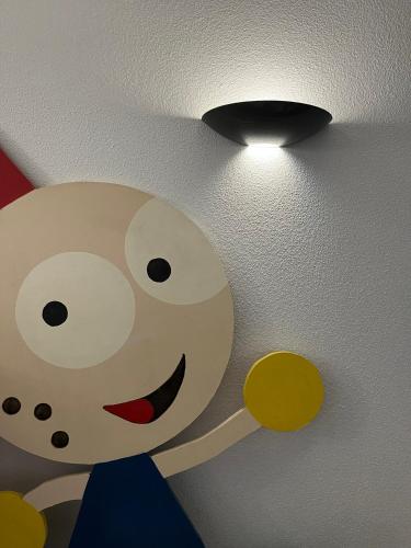a light on a ceiling with a cartoon face on it at Hôtel Le Lacuzon in Moirans-en-Montagne