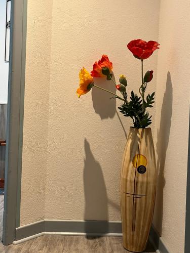 a vase with flowers in it on a wall at Hôtel Le Lacuzon in Moirans-en-Montagne