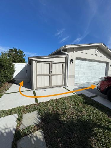 a house with two garage doors and a driveway at Sunshine Nest in Lehigh Acres