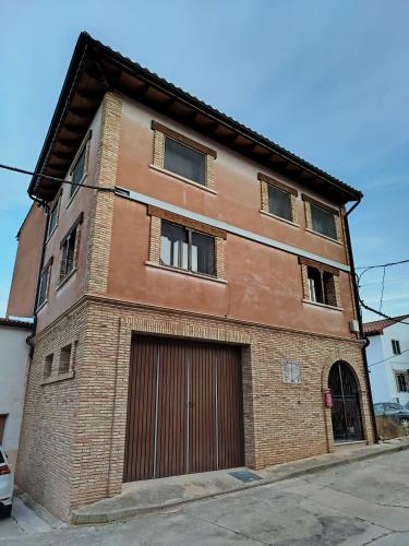an old brick building with a garage at El pony pisador in El Poyo