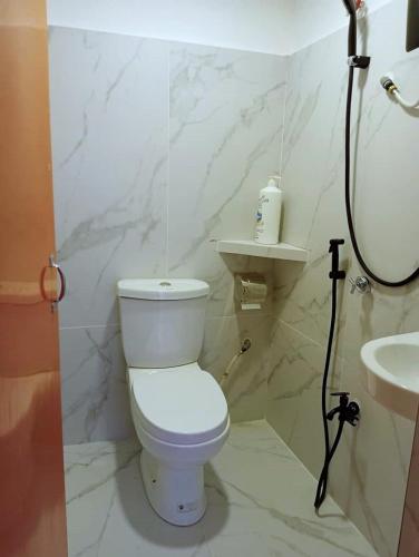 a white bathroom with a toilet and a sink at H Budget Hotel in Johor Bahru