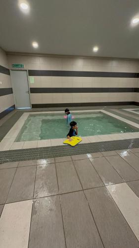 a young child playing in a swimming pool at farissa homestay in Melaka