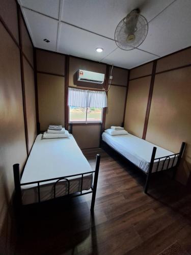 a room with two beds and a window at Benteng Taman Negara in Jerantut