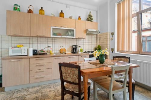 Golden Villa - in the Heart of Old Town Bucharest في بوخارست: مطبخ مع طاولة خشبية وطاولة وكراسي