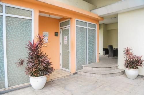 an office with two potted plants in front of a building at Pacific Bay Grand Suites in Manila