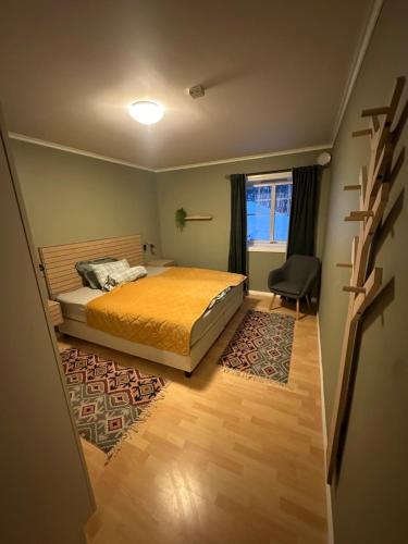 a bedroom with a bed and a window and a chair at Apartment close to nature in Tromsø