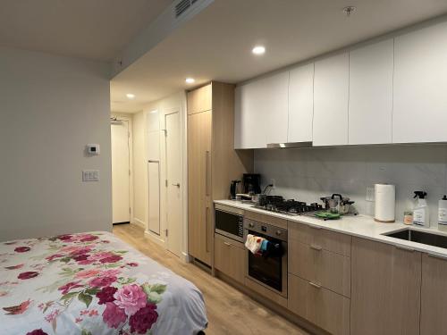a kitchen with white cabinets and a stove top oven at New condo near Lougheed Mall & SFU in Coquitlam