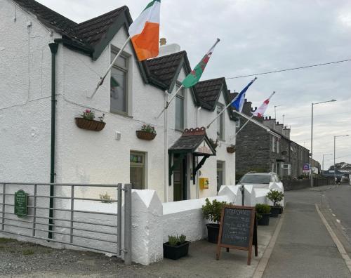 a building with flags on the side of it at Holland Hotel in Llanfachraeth