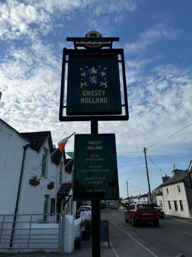 a street sign on a pole on a street at Holland Hotel in Llanfachraeth