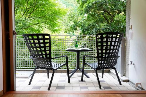 two chairs and a table on a screened in porch at Sakura Residence Hakone in Hakone