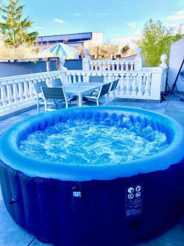 a blue hot tub on a patio with chairs at Apartments C'EST LA SEA - Whirlpool-Suite oder Dachterrassen-Suite in Neusiedl am See
