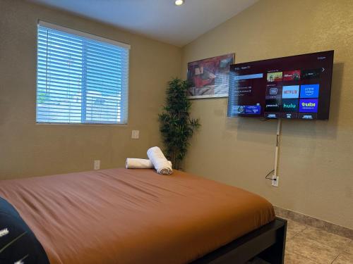 a bedroom with a bed and a flat screen tv at 3 Bedroom, 2 Bath Whole House, Arizona State Univ, Tempe, Mesa Scottsdale on Light Rail, Dogs ok, Work Space in Mesa
