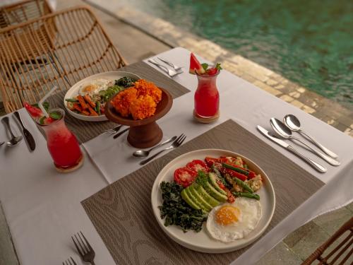 a table with two plates of food on it at Tattva Ubud Retreat & Wellness in Ubud